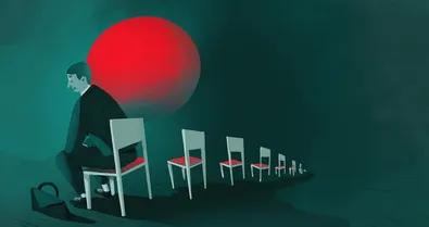 A man in a suit sitting in an empty row of chairs