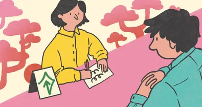 A person at a desk with the help mark on it accommodates a hearing impaired person by writing instead of speaking.